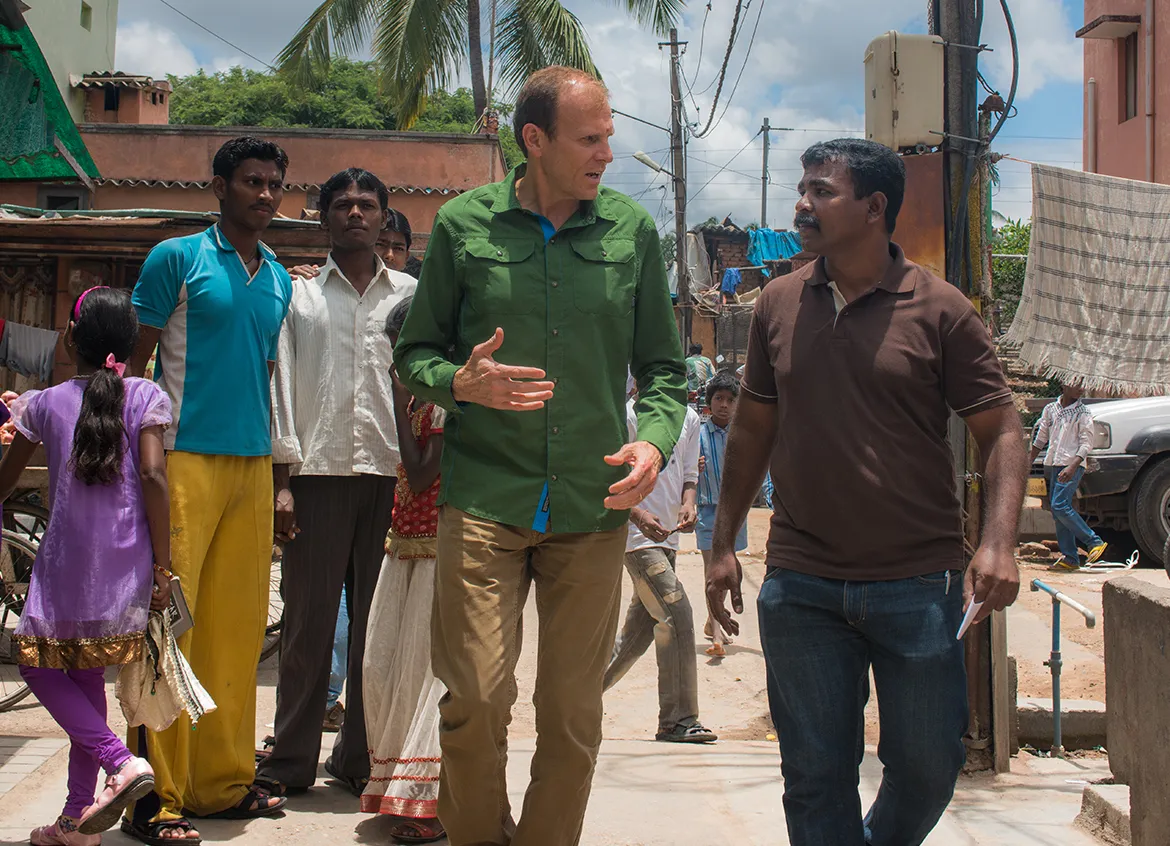 Gary White walking down the street with a man in India.